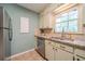Kitchen with stainless steel dishwasher, tile backsplash, and plentiful natural light from the window at 284 Zion Wood Rd, Loganville, GA 30052