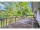 Wooden back deck surrounded by lush greenery, offering a serene outdoor space for relaxation and entertainment at 3150 Stonewall Tell Rd, Atlanta, GA 30349