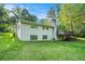 Spacious backyard featuring lush green lawn, a brick home with a deck, and mature trees, offering privacy and natural beauty at 3150 Stonewall Tell Rd, Atlanta, GA 30349