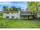 Expansive backyard featuring lush green lawn, brick house with a large deck, and mature trees for privacy at 3150 Stonewall Tell Rd, Atlanta, GA 30349