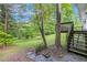 Backyard scene featuring stairs leading to a raised deck, surrounded by lush greenery and mature trees at 3150 Stonewall Tell Rd, Atlanta, GA 30349
