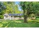 Charming ranch home features a brick exterior, well-manicured lawn, and mature trees, creating a serene setting at 3150 Stonewall Tell Rd, Atlanta, GA 30349