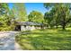 Charming single-story home with a well-manicured lawn, carport, and mature trees at 3150 Stonewall Tell Rd, Atlanta, GA 30349