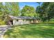 A charming single story home with carport nestled amongst lush greenery and a sprawling lawn at 3150 Stonewall Tell Rd, Atlanta, GA 30349