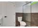 Modern bathroom featuring a walk-in shower and toilet against a backdrop of gray and white tile at 644 Glendale Rd, Scottdale, GA 30079