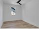 A white bedroom with wood floors, a ceiling fan, and a window that lets in natural light at 644 Glendale Rd, Scottdale, GA 30079