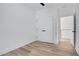 A white bedroom with wood floors, a closet, and a door that leads to another room at 644 Glendale Rd, Scottdale, GA 30079
