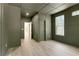 Modern bedroom featuring wood floors and olive walls with a door that opens up to a bright hallway at 644 Glendale Rd, Scottdale, GA 30079
