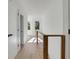Hallway features hardwood flooring, a wooden railing, and a sunlit view through the window at 644 Glendale Rd, Scottdale, GA 30079