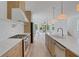 Open kitchen with large island, stainless steel appliances, and light wood cabinets overlooking a light-filled living space at 644 Glendale Rd, Scottdale, GA 30079