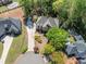 A high-angle view displays a brick home with lush landscaping, a winding driveway, and mature shade trees at 860 Cramac Dr, Lawrenceville, GA 30046
