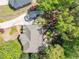 An aerial view of a home nestled in green trees, with a stone patio, a lush lawn, and an extra parking area at 860 Cramac Dr, Lawrenceville, GA 30046