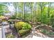Spacious backyard with a patio, pond, play set, and mature trees at 860 Cramac Dr, Lawrenceville, GA 30046