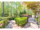 A stone pathway leads to a wooden deck with a cozy outdoor swing, surrounded by lush trees and manicured greenery at 860 Cramac Dr, Lawrenceville, GA 30046