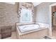The bathroom features a jacuzzi tub under a stained-glass window, stylish wallpaper, and tiled floor at 860 Cramac Dr, Lawrenceville, GA 30046