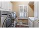 Laundry room includes front loading washer and dryer, plantation shutters, and tile flooring at 860 Cramac Dr, Lawrenceville, GA 30046