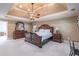 This main bedroom features a tray ceiling with fan, carpet, and classic wood bedroom set at 860 Cramac Dr, Lawrenceville, GA 30046