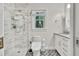 Modern bathroom with glass shower, patterned tile floor, and white vanity at 1972 Tanglewood Dr, Snellville, GA 30078
