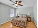 Cozy bedroom features a floral-patterned bed, hardwood floors, and a ceiling fan at 1972 Tanglewood Dr, Snellville, GA 30078