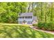 View of the beautiful home with a well-manicured lawn and lush trees surrounding the property at 1972 Tanglewood Dr, Snellville, GA 30078