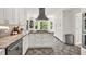 Kitchen boasts custom white cabinetry, granite countertops, stainless steel appliances, and gray tile floor at 1972 Tanglewood Dr, Snellville, GA 30078