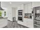 Kitchen boasts custom white cabinetry, granite countertops, stainless steel appliances, and gray tile floor at 1972 Tanglewood Dr, Snellville, GA 30078