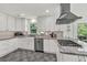 Bright kitchen with granite countertops, stainless steel appliances, custom cabinets, and gray tile floor at 1972 Tanglewood Dr, Snellville, GA 30078