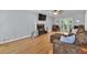 Bright living room featuring a brick fireplace, hardwood floors, ceiling fan, and access to the backyard at 1972 Tanglewood Dr, Snellville, GA 30078