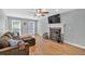 Inviting living room featuring hardwood floors, fireplace, ceiling fan, and a comfortable sectional sofa at 1972 Tanglewood Dr, Snellville, GA 30078