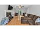 Bright living room featuring a brick fireplace, hardwood floors, ceiling fan, and access to the backyard at 1972 Tanglewood Dr, Snellville, GA 30078