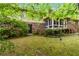 Picturesque backyard features lush greenery, a brick exterior, and a cozy sunroom at 2343 Kings Point Dr, Dunwoody, GA 30338