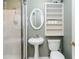 Cozy bathroom with glass shower, toilet, sink, oval mirror, and shelving for storage at 2343 Kings Point Dr, Dunwoody, GA 30338