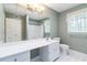 Spacious bathroom featuring a long countertop, mirror, commode, white tile floor and shower at 2343 Kings Point Dr, Dunwoody, GA 30338