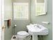 Bathroom featuring toilet, sink, mirror, window with blinds, and dark green wall color at 2343 Kings Point Dr, Dunwoody, GA 30338
