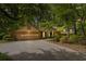 Charming home featuring an attached garage and a well-manicured lawn with beautiful mature trees at 2343 Kings Point Dr, Dunwoody, GA 30338