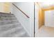 Carpeted stairway with white risers and a wooden handrail, illuminated by overhead lighting at 2343 Kings Point Dr, Dunwoody, GA 30338