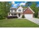 Charming two-story traditional home featuring a manicured front yard and a brick-accented attached two-car garage at 2979 Sweetbriar Walk, Snellville, GA 30039