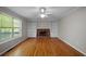 Cozy living room with hardwood floors, a brick fireplace flanked by built-in shelves, and a ceiling fan at 2979 Sweetbriar Walk, Snellville, GA 30039
