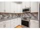 This kitchen features white cabinets, stainless steel appliances, and granite countertops at 4960 Shannon Sw Way, Mableton, GA 30126