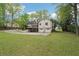 View of the rear side of the house with a spacious lawn, driveway, and two-car garage at 2972 Nw Stilesboro Nw Rd, Kennesaw, GA 30152