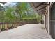 Expansive white wooden deck featuring dark wood railings, access to home via glass doors, and green backyard views at 2972 Nw Stilesboro Nw Rd, Kennesaw, GA 30152