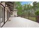 This large white wooden deck features a dark wood railing, exterior lights, and access to the home via glass doors at 2972 Nw Stilesboro Nw Rd, Kennesaw, GA 30152