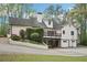 Two story home with a two-car garage, white siding, black shutters and a rear wooden deck and lush landscaped yard at 2972 Nw Stilesboro Nw Rd, Kennesaw, GA 30152