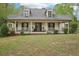 Inviting home boasts a covered front porch, complemented by well-manicured landscaping at 2972 Nw Stilesboro Nw Rd, Kennesaw, GA 30152