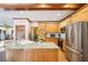 Well-lit kitchen features wooden cabinets, stainless steel refrigerator, and a granite countertop island at 2972 Nw Stilesboro Nw Rd, Kennesaw, GA 30152
