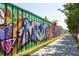 Green space walk way with colorful graffiti covered barrier at 35 Moda Ln, Atlanta, GA 30316