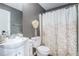 Neutral bathroom with a leafy pattern shower curtain, toilet, and white vanity at 4180 West Stubbs Rd, College Park, GA 30349