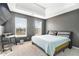 Bedroom featuring a tray ceiling, two windows, gray walls, carpet, and a desk near the window at 4180 West Stubbs Rd, College Park, GA 30349