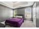 Bedroom with a tray ceiling, two windows, gray walls, carpet, and a queen bed covered with a purple comforter at 4180 West Stubbs Rd, College Park, GA 30349