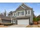 Charming two-story home with a gray exterior, stone accents, black shutters, and a two-car garage at 9032 Jim Purcell Dr, Covington, GA 30014